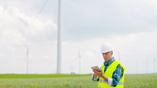 Ingenieur verwendet digitales Tablet bei der Inspektion von Windkraftanlagen