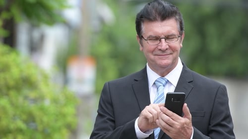 Man in Suit Uses Mobile Phone Outdoors