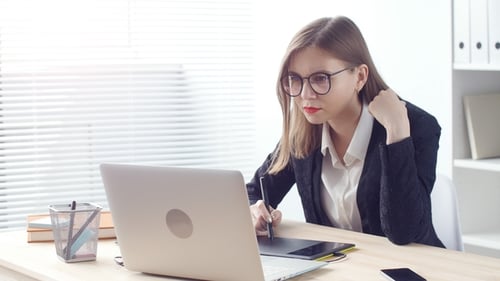 Young Woman Works at Laptop in Bright Office