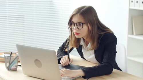 Woman Uses Graphics Tablet with Laptop in Office