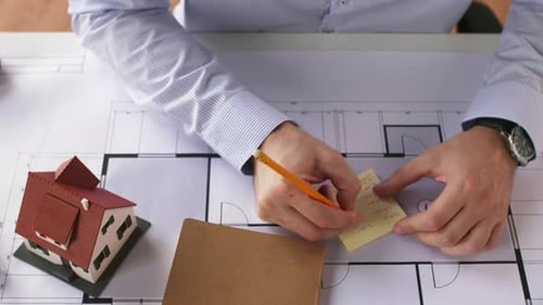 Architect Planning Home Design with Scale Model