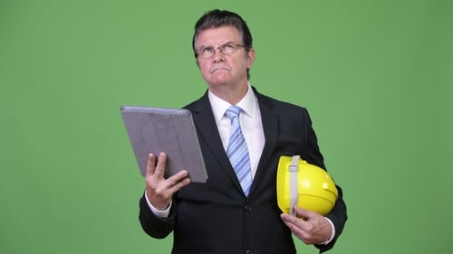 Gut aussehender Geschäftsmann als Ingenieur mit digitalem Tablet
