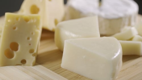 Assorted Cheeses Rotating on Wooden Board