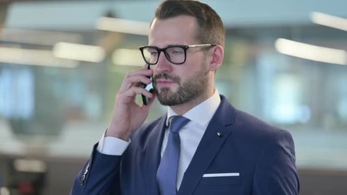 Man In Suit Answering Mobile Phone In Office