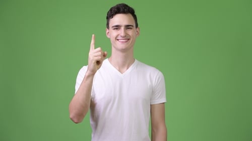 Young Adult Points Finger Upwards in Front of Greenscreen