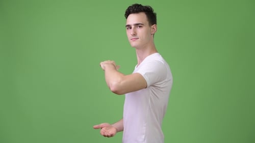 Man in White Shirt Gesturing on Green Background