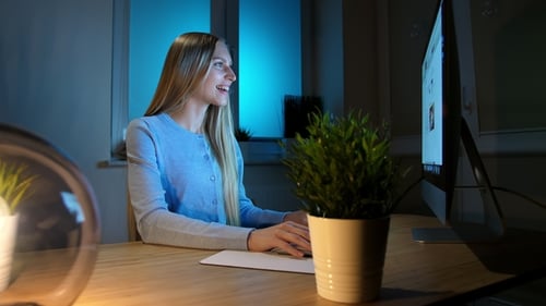 Smiling Woman Working on Computer at Night