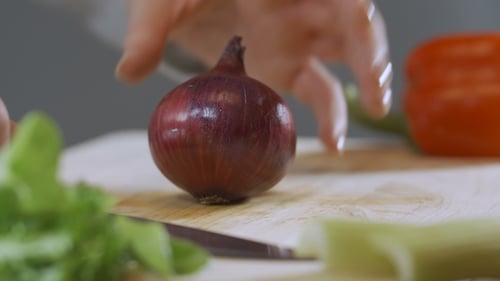 Red Onion Being Cut on a Cutting Board