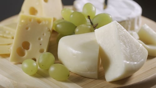 Cheese and Grapes on Wooden Board