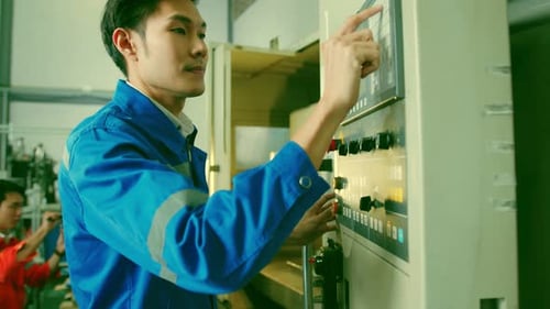 Male Asian engineer professional hand control machine screen in the factory