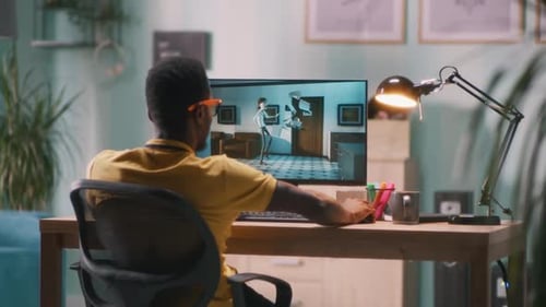 Young Adult Watching Animation on Computer at Desk