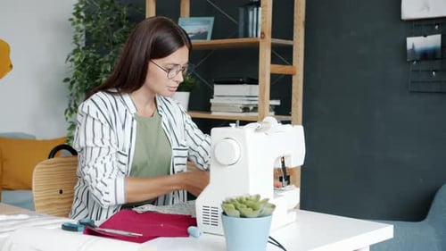 Woman Sewing with Machine at Desk Indoors