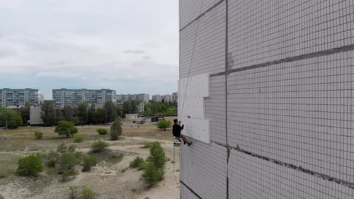 Industrial Alpinism. Aerial View. Work on Outer Insulate Building with Styrofoam