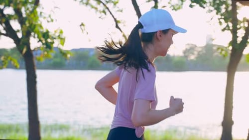 Asian young beautiful sport woman running on street in public park.