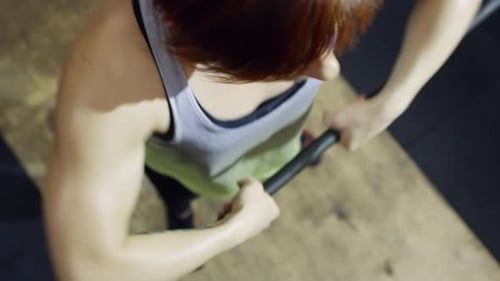 Woman Preparing for a Barbell Lift at the Gym