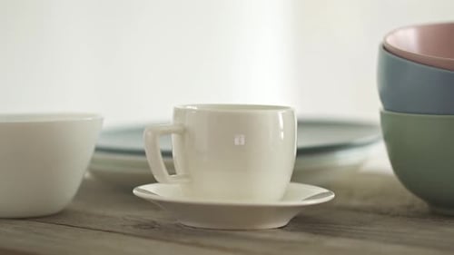 Ein großes Set an sauberem Geschirr. Ein Stapel weißer und grauer Teller und eine Kaffeetasse und eine Untertasse
.