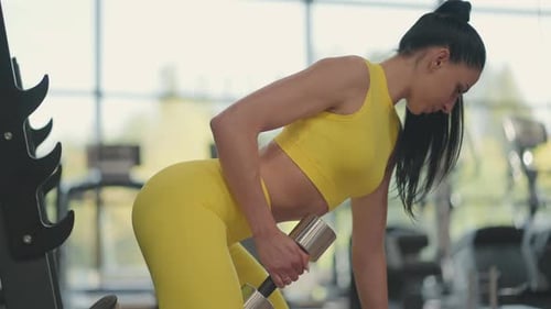 Fit Woman Doing Dumbbell Row at Gym
