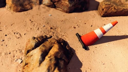 Cono de seguridad vial en una playa de arena vacía