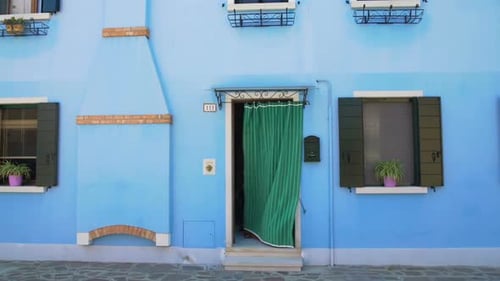 Beautiful View on Tidy Blue House With Flowerpots on Windows, Burano, Venice