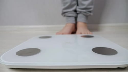 Bare Feet Step on Bathroom Scale for Weight Check