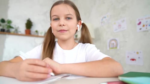 Smiling Girl Waves During Online Lesson at Home