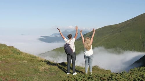 Pareja alcanzando la cima de la colina