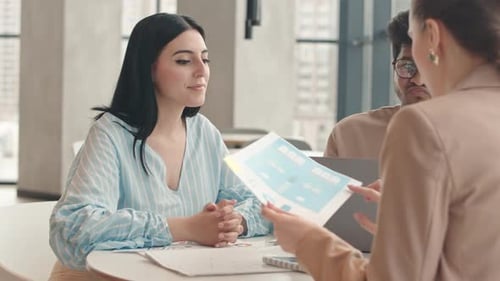 Colleagues Discussing Business Documents in Cafe
