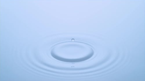Droplet Creates Ripple Effect in Blue Water