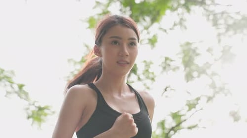 Asian young beautiful sport woman exercise by running on street in evening sunset in public park.
