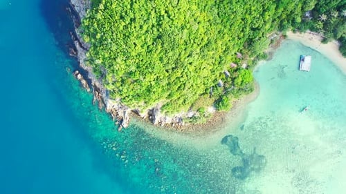 Vista aérea de las islas tropicales. Agua de mar aguamarina e isla elevada con árboles exóticos