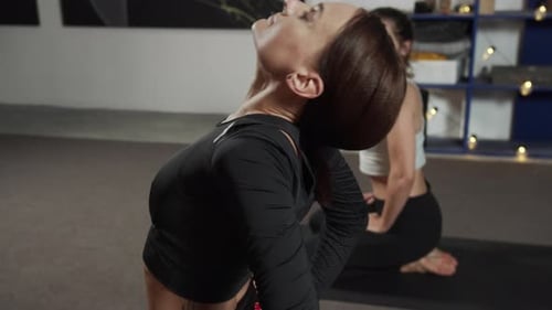 Two Women Practicing Yoga in a Studio