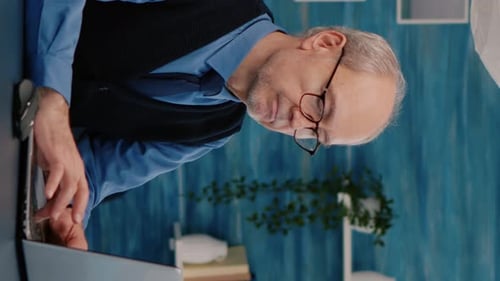 Senior Man Working on Laptop at Desk