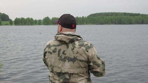 Fisherman Spinning Fishing Reel. Fishing on Summer River