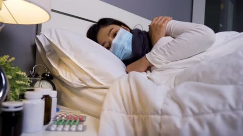 Woman Wearing Mask Lying in Bed at Home