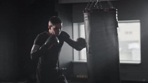 Man Boxing, Training with Punching Bag in Gym