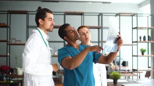 Multi-ethnic Group of Professional Doctors with X-ray Image of Patient Are Meeting and Discussing .