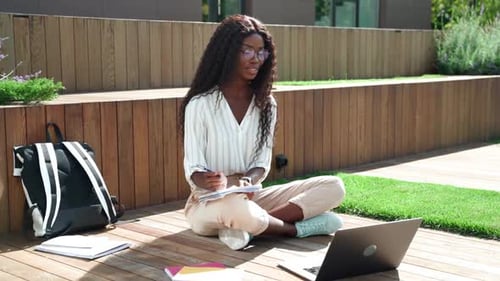 Young Woman Studying with Laptop Outdoors