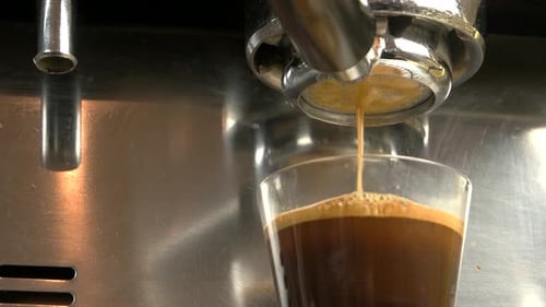 Fresh Espresso Pours into Glass Cup