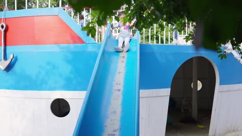 4K Little Asian girl sliding and playing at playground in the park