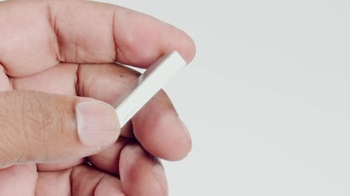 Hand Holding and Rotating Block of Metal Staples