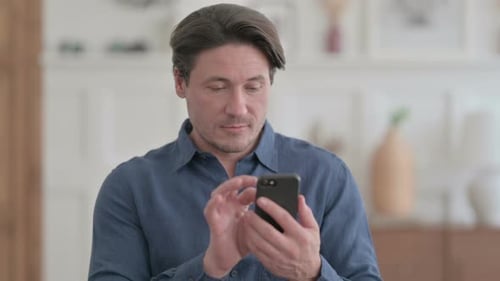 Man Using Smartphone Indoors in Mid Shot