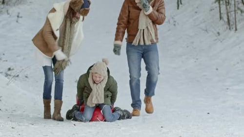 Pais correndo atrás do menino no trenó
