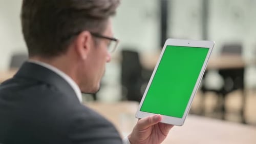 Businessman Using Tablet with Green Screen in Office