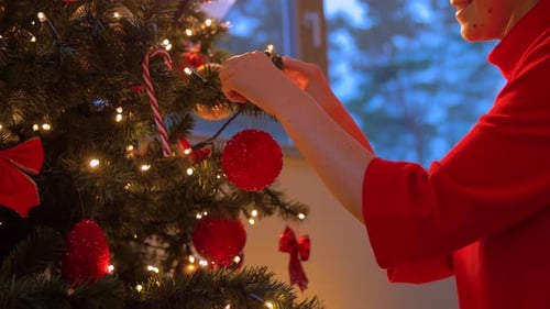 Woman Decorating Christmas Tree With Ornaments