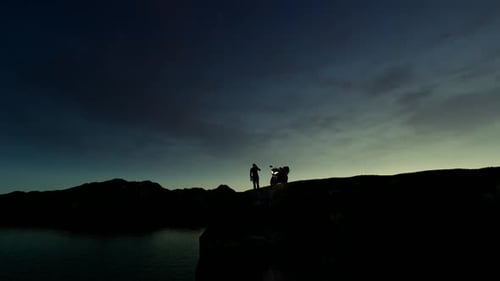 Man Watching the view of the Cliff with his Motorcycle