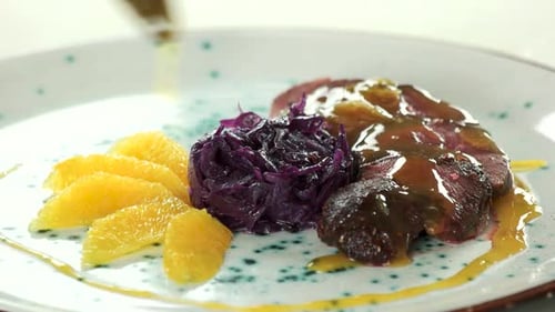 Gourmet Meat Dish with Cabbage and Oranges