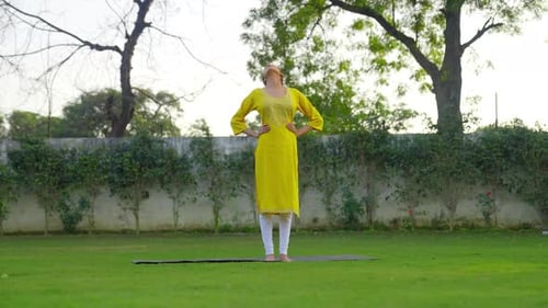 Neck Stretch Yoga is being done by an Indian woman in an Indian dress