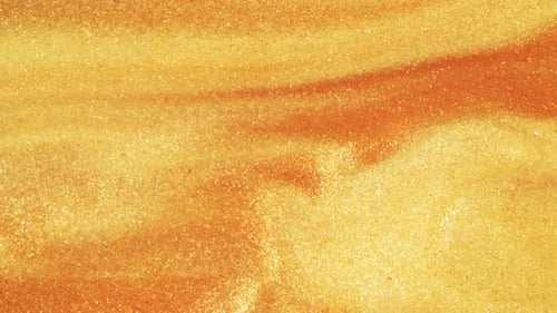 Colorful Golden Sand Organically Moves in Colorful Liquid in Macro