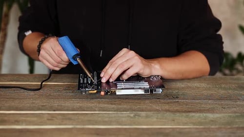 Technician Soldering Electronic Component on Computer Part