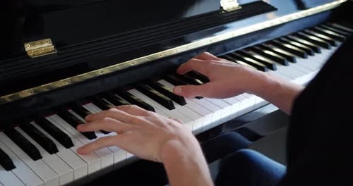 Hands Playing Keys of Upright Piano